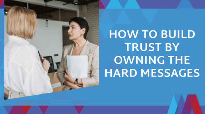 Blog Feature Image With Title: How To Build Trust By Owning The Hard Messages. Two Women Having A Direct Conversation In A Professional Office Setting.