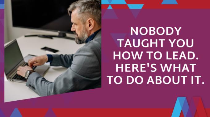 Man In A Suit Working On A Laptop At A Desk, Beside Text Reading 'Nobody Taught You How To Lead. Here's What To Do About It.' — Mosaic People Development Blog On Leadership Training